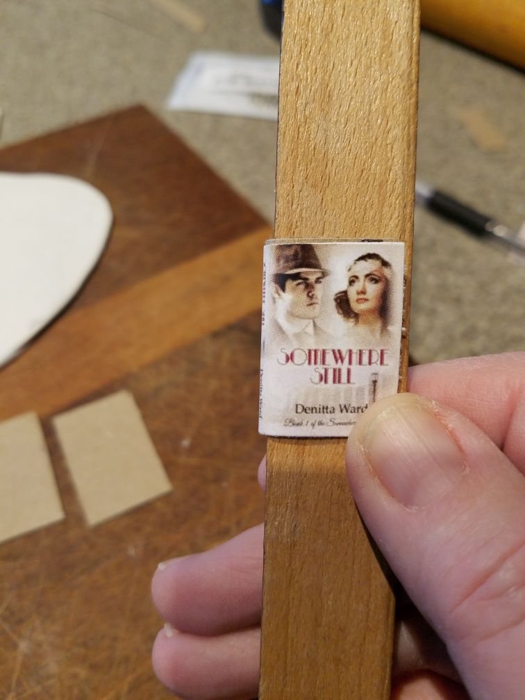 The front cover of a mini book held against a ruler edge