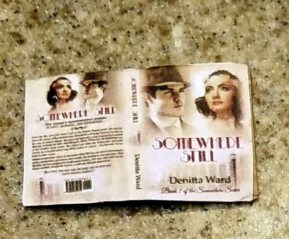 A printed wrap-around cover of Somewhere Still lying on a granite countertop